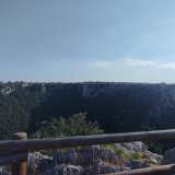 Dopo pochi metri incontriamo un belvedere protetto da una staccionata in legno che permette di godere di una vista panoramica della gravina